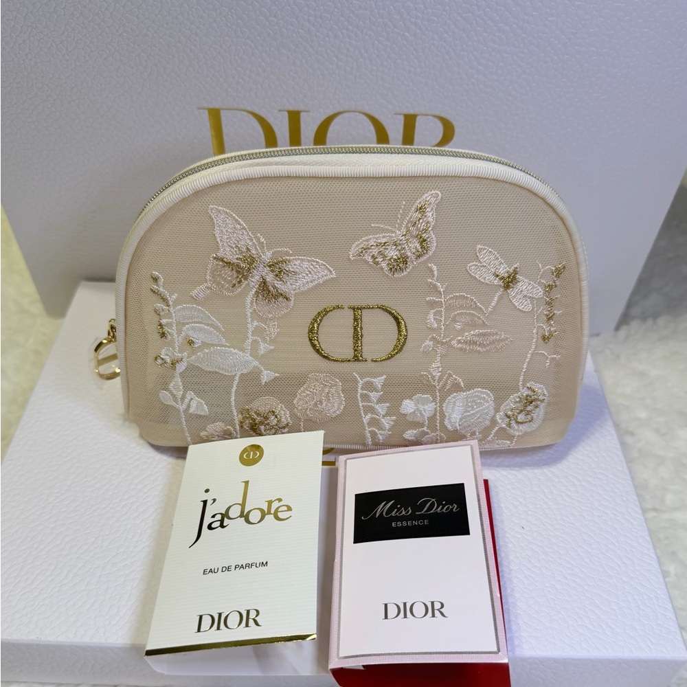 Dior cream-colored embroidered cosmetics case; includes two perfume samples.